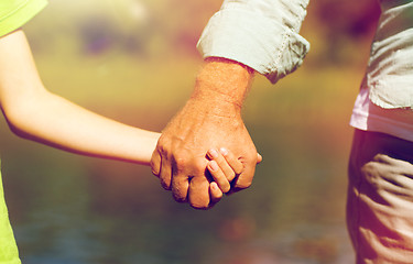 Image showing senior man and child holding hands