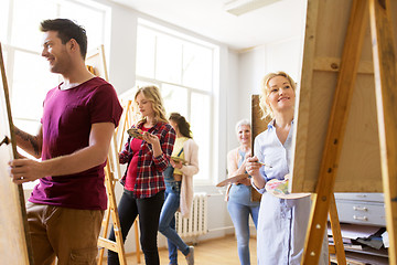 Image showing artists with brushes painting at art school