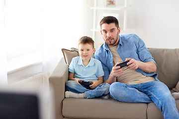 Image showing father and son playing video game at home