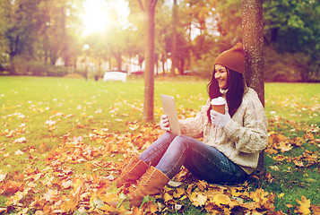 Image showing woman with tablet pc and coffee in autumn park