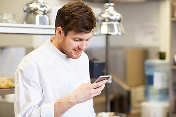 Image showing chef cook with smartphone at restaurant kitchen