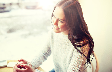 Image showing smiling young woman drinking tea at cafe