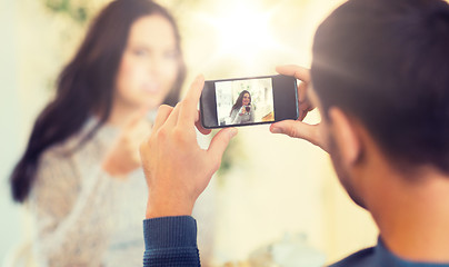 Image showing man taking picture of woman by smartphone at cafe