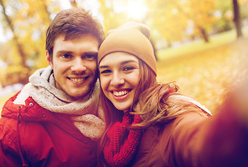 Image showing happy young couple taking selfie in autumn park