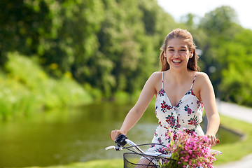 Image showing happy woman riding fixie bicycle in summer park