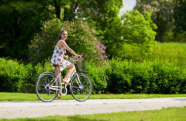 Image showing happy woman riding fixie bicycle in summer park