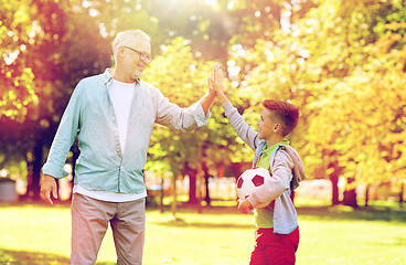 Image showing old man and boy with soccer ball making high five