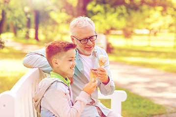 Image showing old man and boy eating ice cream at summer park