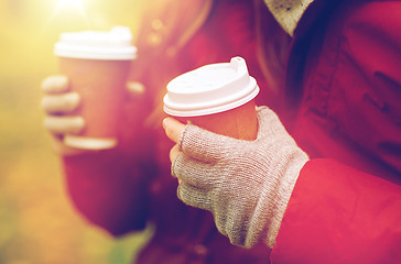 Image showing close up of couple hands with coffee in autumn