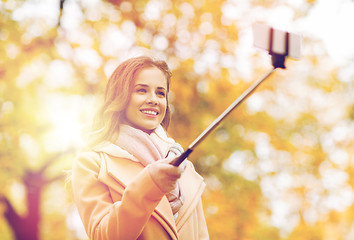 Image showing woman taking selfie by smartphone in autumn park