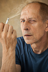 Image showing Worried mature man sitting at studio