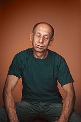 Image showing Worried mature man sitting at studio