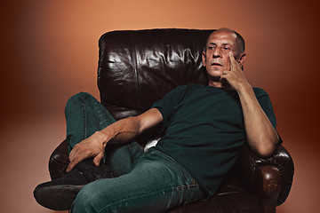 Image showing Worried mature man sitting at studio