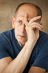 Image showing Worried mature man touching his head.