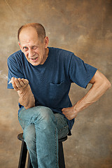 Image showing Worried mature man sitting at studio