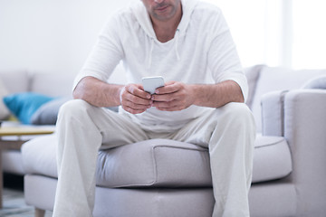 Image showing young man using a mobile phone  at home