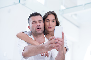 Image showing happy couple using mobile phone at home