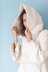 Image showing woman in a white coat with hood isolated on blue background