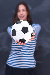 Image showing woman holding a soccer ball in front of chalk drawing board