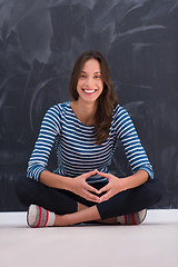 Image showing woman sitting in front of chalk drawing board