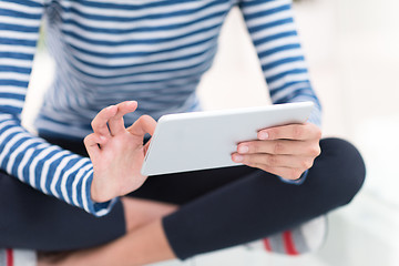 Image showing young women using tablet computer on the floor