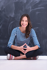 Image showing woman sitting in front of chalk drawing board