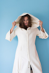 Image showing woman in a white coat with hood isolated on blue background