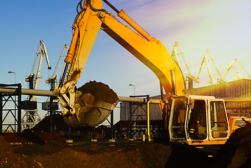 Image showing Hydraulic excavator at work. Shovel bucket and cranes against bl