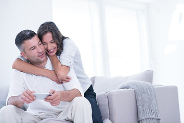 Image showing happy couple using mobile phone at home