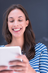 Image showing woman using tablet  in front of chalk drawing board