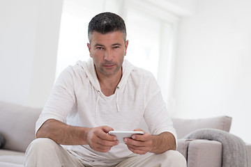 Image showing young man using a mobile phone  at home