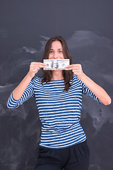 Image showing woman holding a banknote in front of chalk drawing board