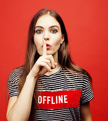 Image showing young pretty emitonal posing teenage girl on bright red background, happy smiling lifestyle people concept 