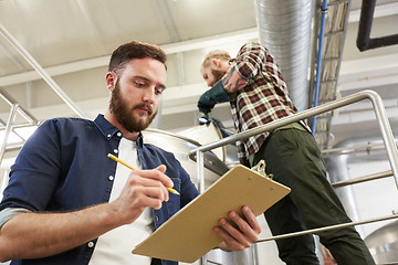 Image showing men with clipboard at brewery or beer plant kettle