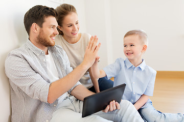 Image showing family with tablet pc at new home making high five