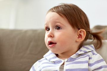 Image showing happy smiling baby girl sitting on sofa at home