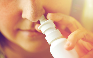 Image showing close up of sick woman using nasal spray