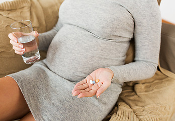 Image showing close up of pregnant woman with pills at home