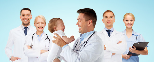 Image showing happy doctor or pediatrician with baby over blue