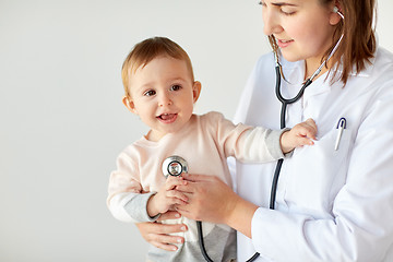 Image showing doctor with stethoscope listening baby at clinic