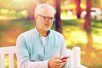 Image showing happy senior man texting on smartphone at summer