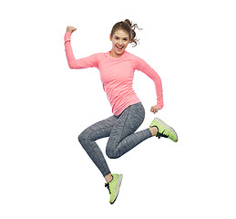 Image showing happy smiling sporty young woman jumping in air