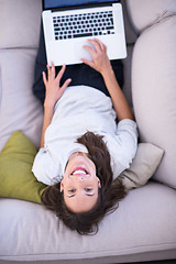 Image showing Young woman using laptop at home top view