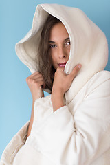 Image showing woman in a white coat with hood isolated on blue background