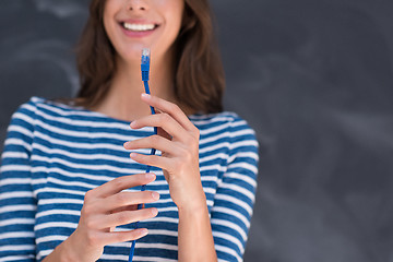 Image showing woman holding a internet cable in front of chalk drawing board