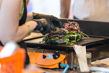 Image showing Chef making beef burgers outdoor on open kitchen international food festival event.