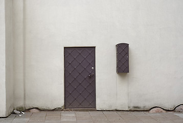 Image showing White stucco wall and metal door.