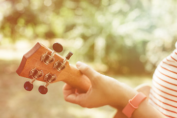 Image showing Anonymous woman playing ukulele