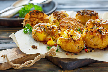 Image showing Baked potatoes in skin with spices, olive oil and garlic.