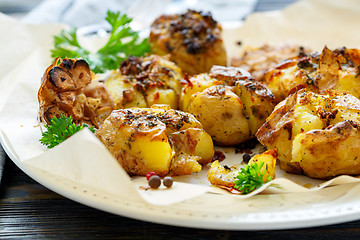 Image showing Potatoes baked in their skins with spices closeup.